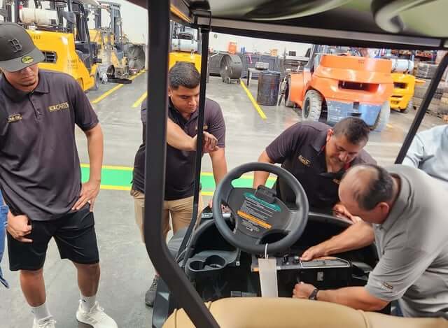 EZCARTS technicians servicing a golf cart
