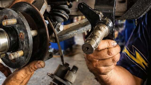 Technician repairing a golf cart wheel hub