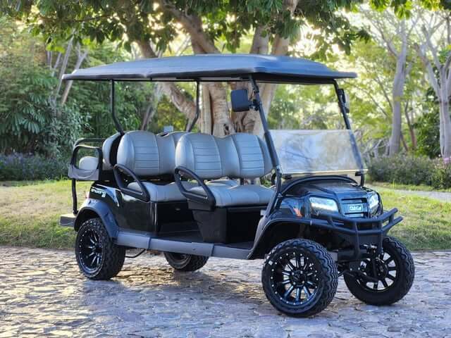 Black Club Car Onward 6 passenger golf cart on a cobblestone street