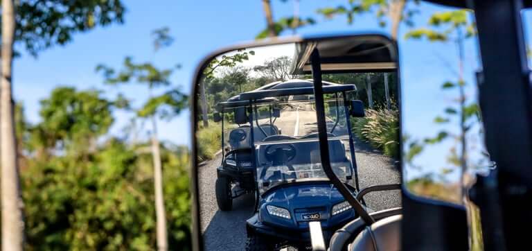 Golf cart reflected in a side mirror on a Punta Mita road